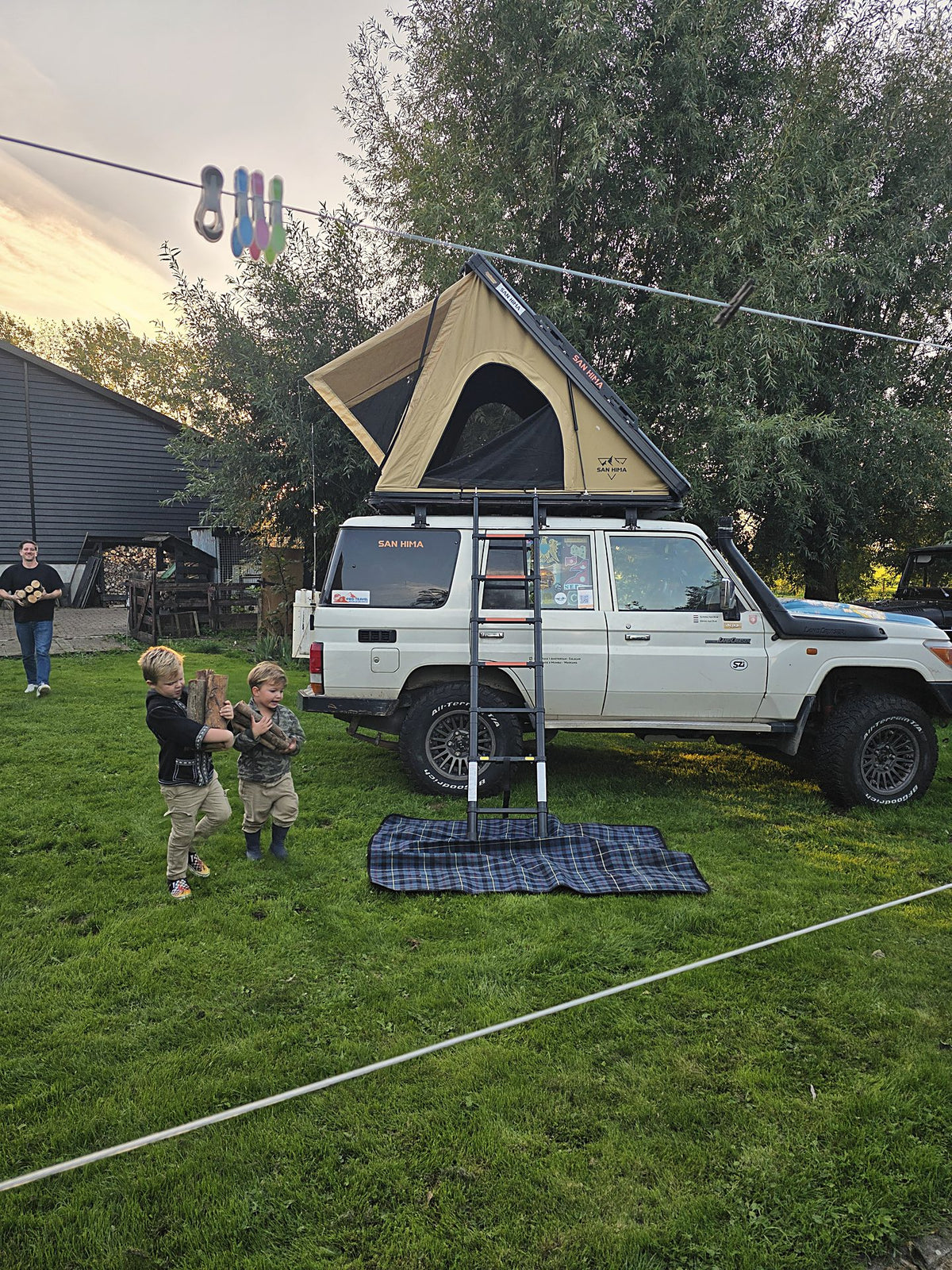 LCM rooftop tent open in the evening with children by the wood fire