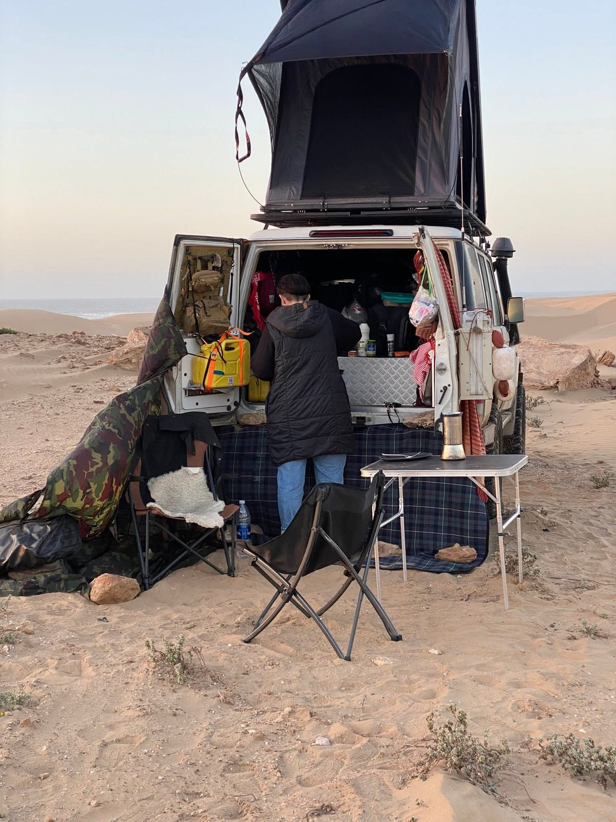 LCM hardshell rooftop tent open at dusk in the Sahara, portrait